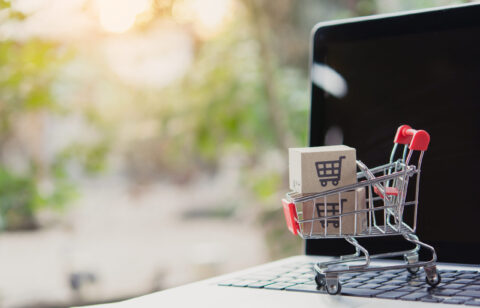 Shopping online. Cardboard box with a shopping cart logo in a trolley on laptop keyboard. Shopping service on The online web. offers home delivery
