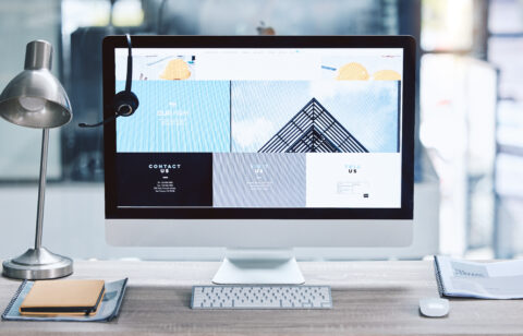 Webpage advert on computer desktop screen monitor in an empty call centre office. Operating helpdes.